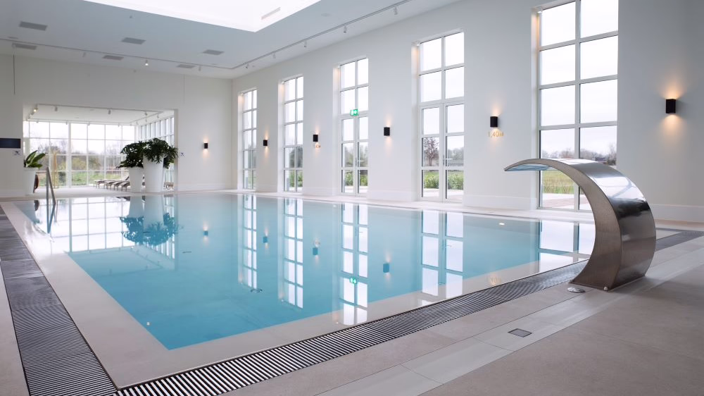 Ein großes Schwimmbad mir hellgrauen Fliesen umrandet