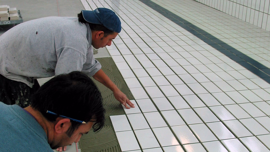Verlegung der neuen Fliesen im Schwimmbecken.