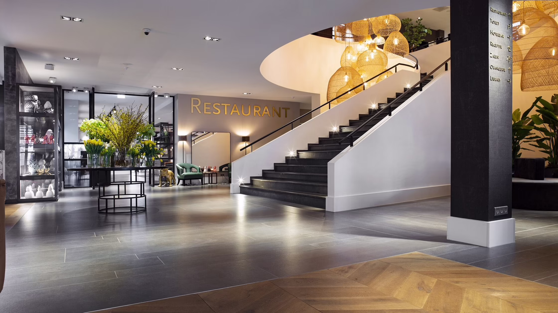 Der weiträumige Eingangsbereich mit Blick auf eine Treppe und den Restauranteingang